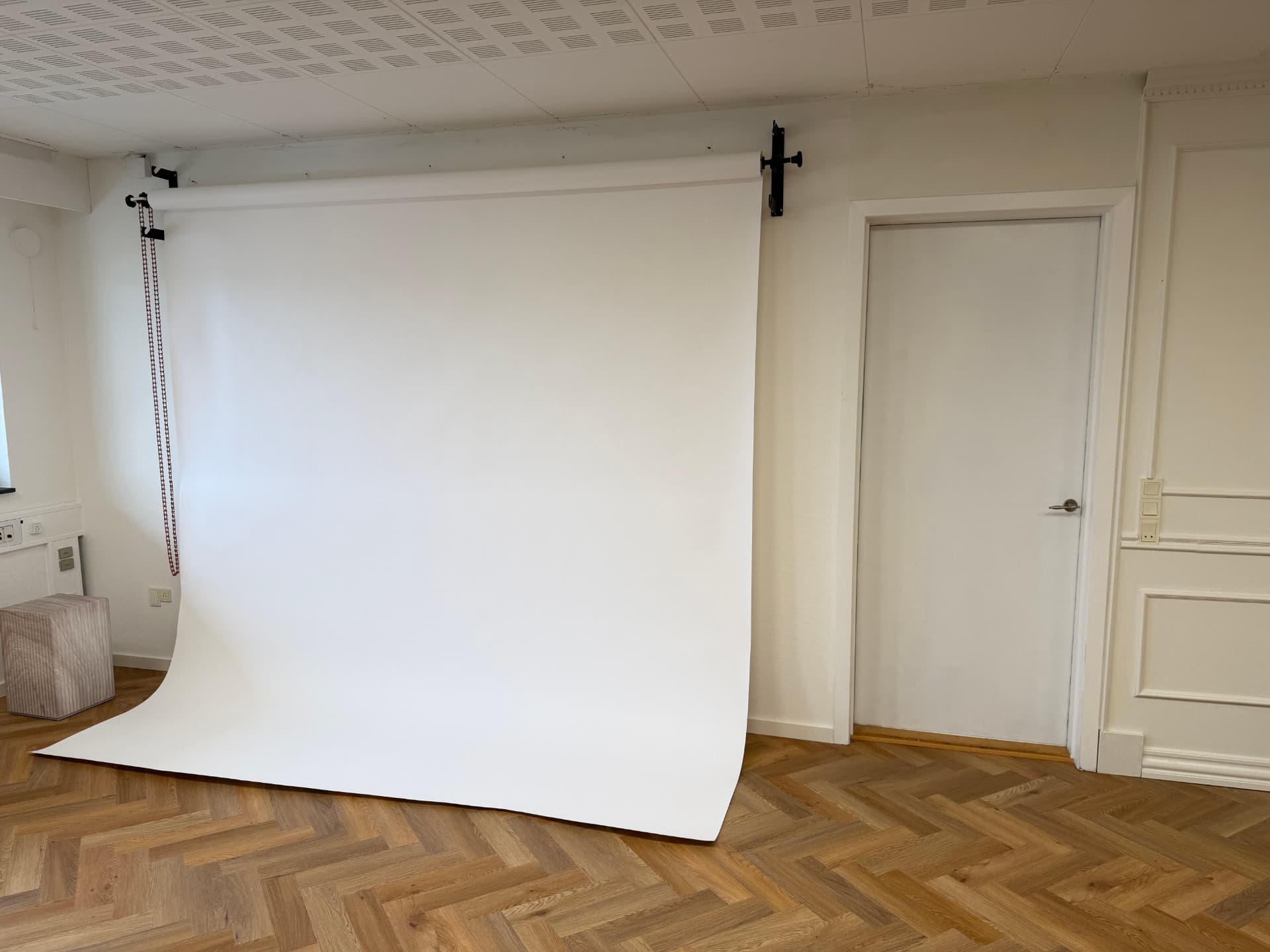 Hvid papirbaggrund rullet ned fra loftsophæng klar til packshots