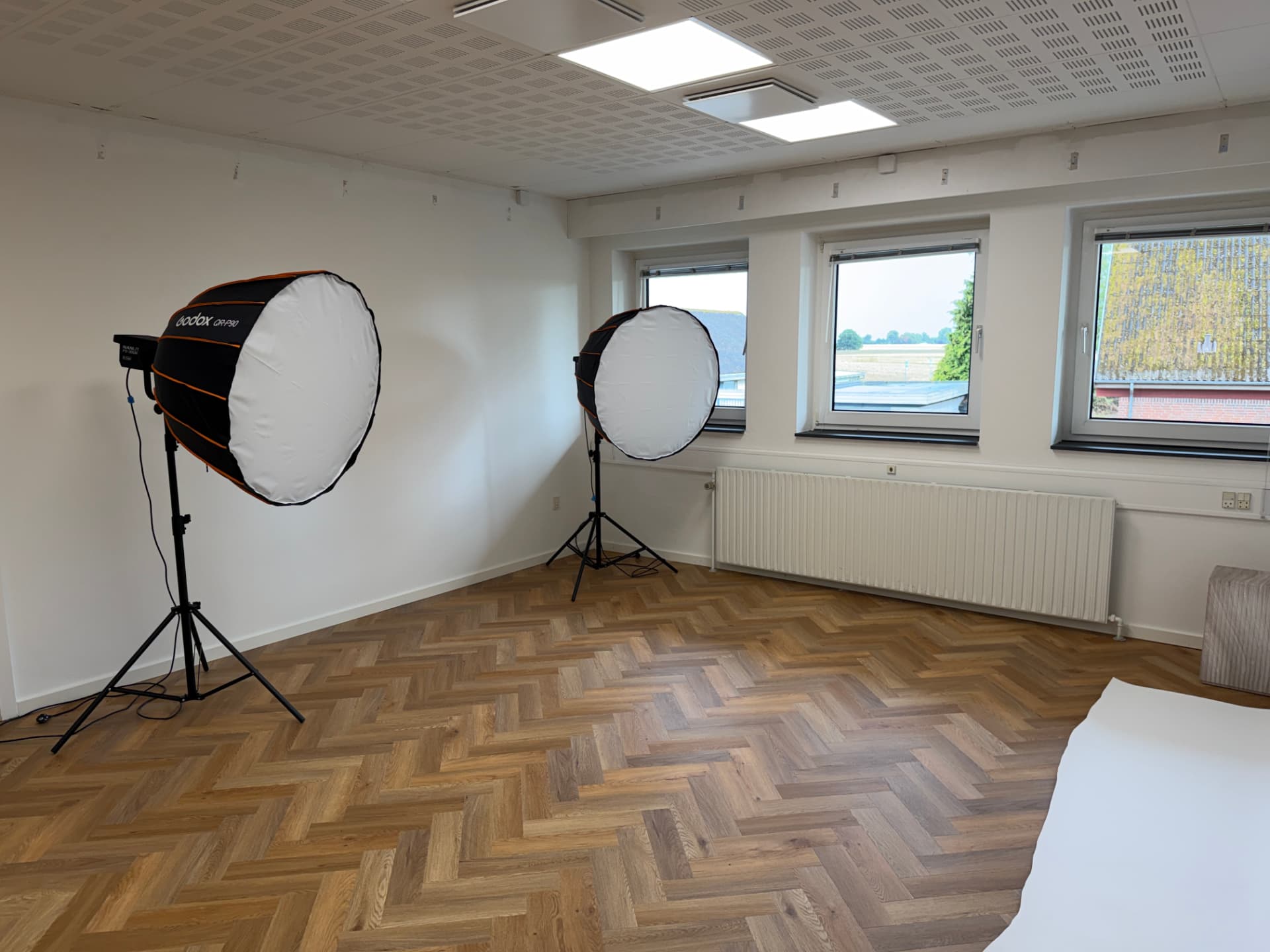 To Godox softboxes på stativer ved vinduesrækken i studiet